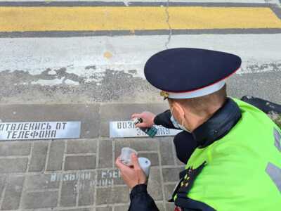 Белгородские автоинспекторы с волонтёрами наносят трафаретом надписи «Отвлекись от телефона»